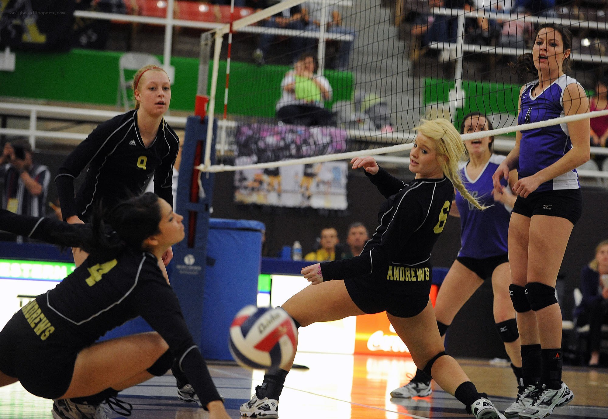 Volleyball player spikes ball