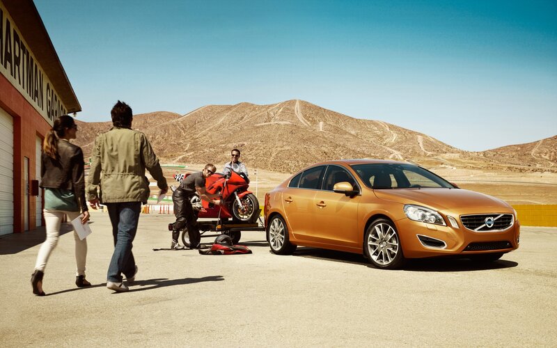Volvo car with motorcycle at racetrack