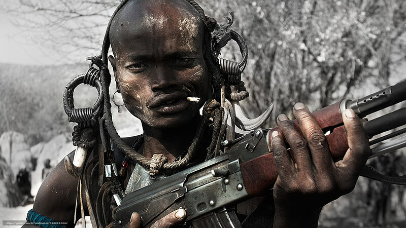 Warrior with rifle and traditional adornments