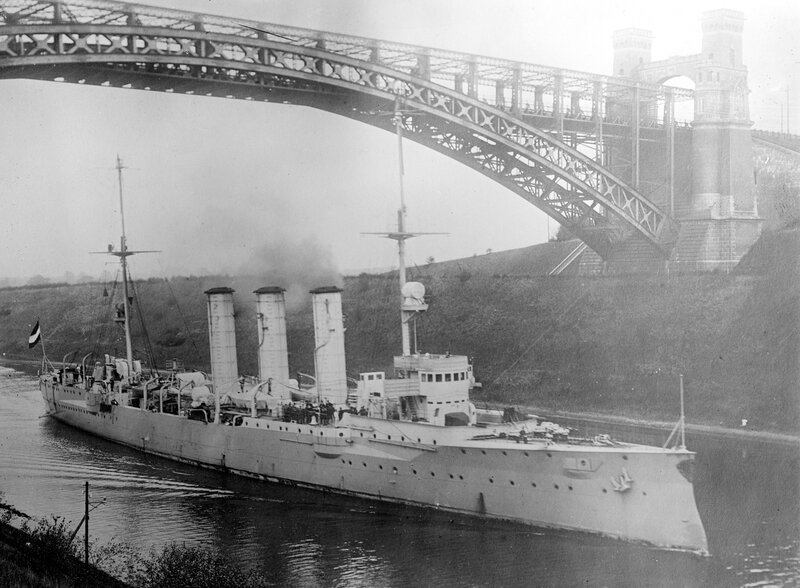 Warship passing under a bridge
