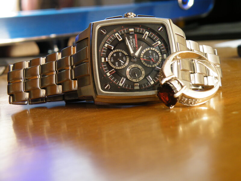 watch and ring on wooden surface