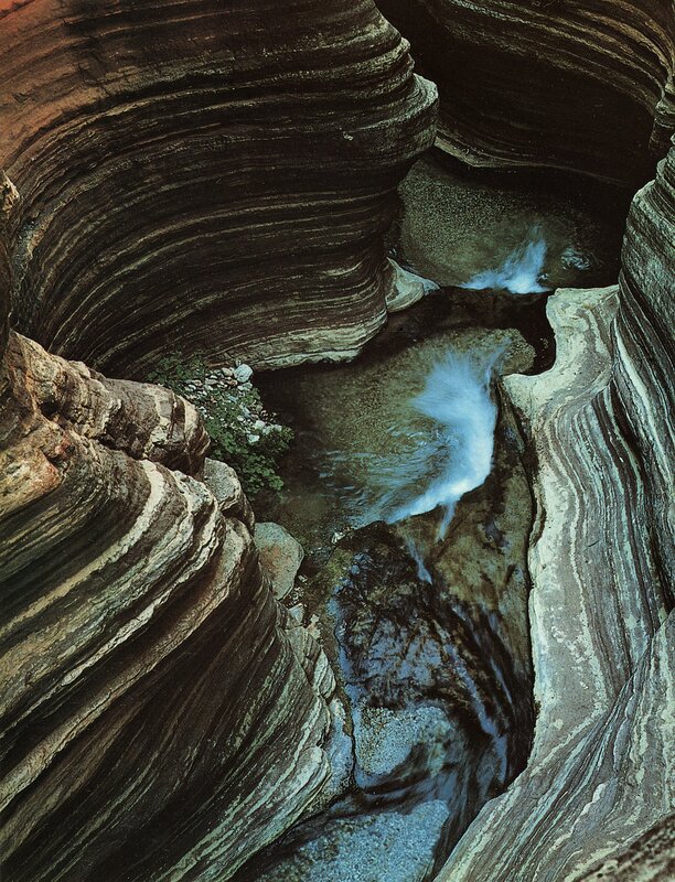 Water carving through rock canyon