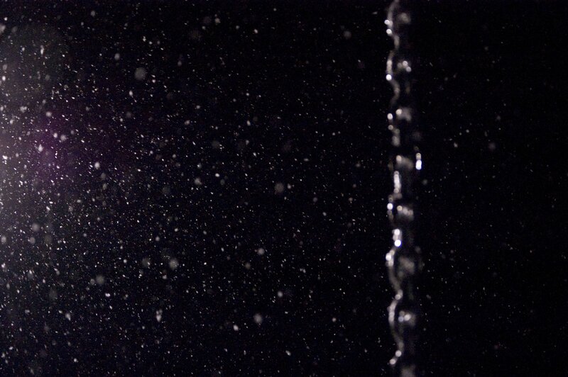 Water droplets falling in darkness