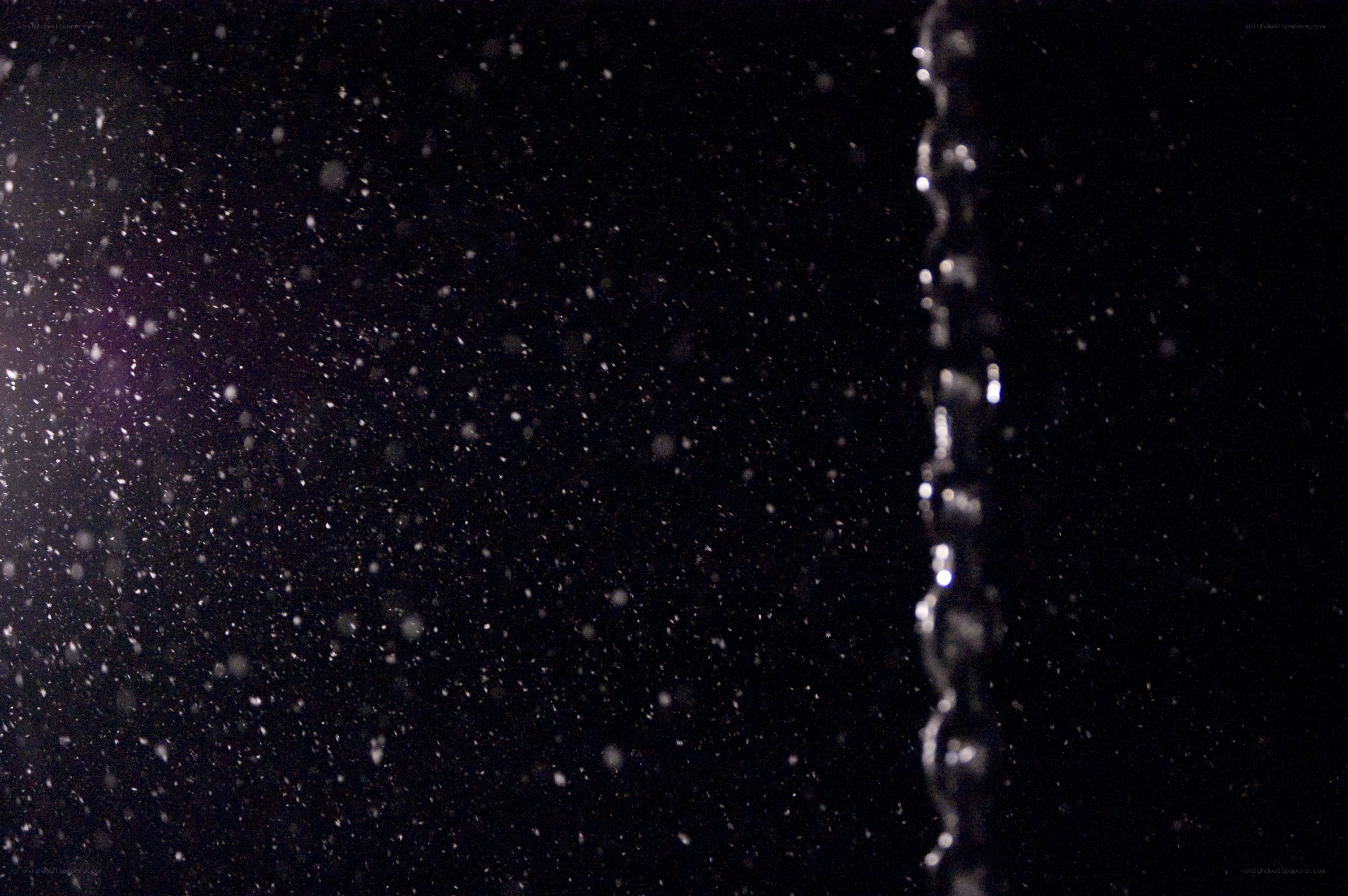 Water droplets falling in darkness