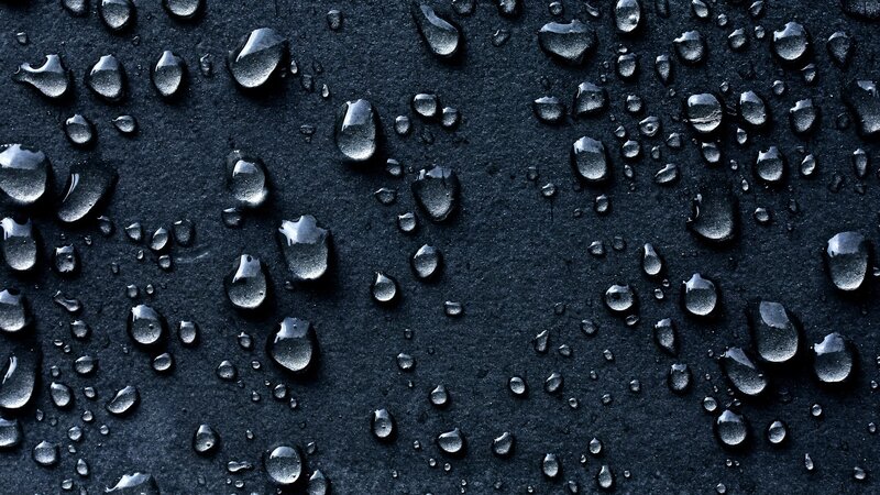 Water Droplets on Black Surface — Photograph