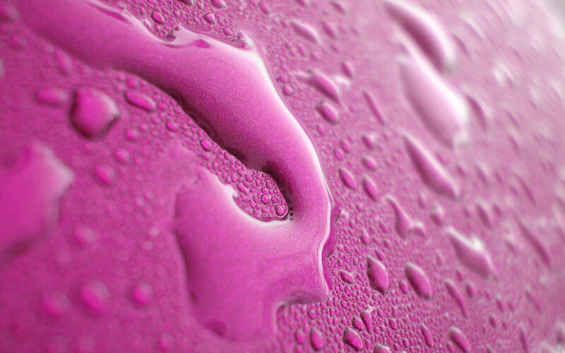 Water droplets on pink surface