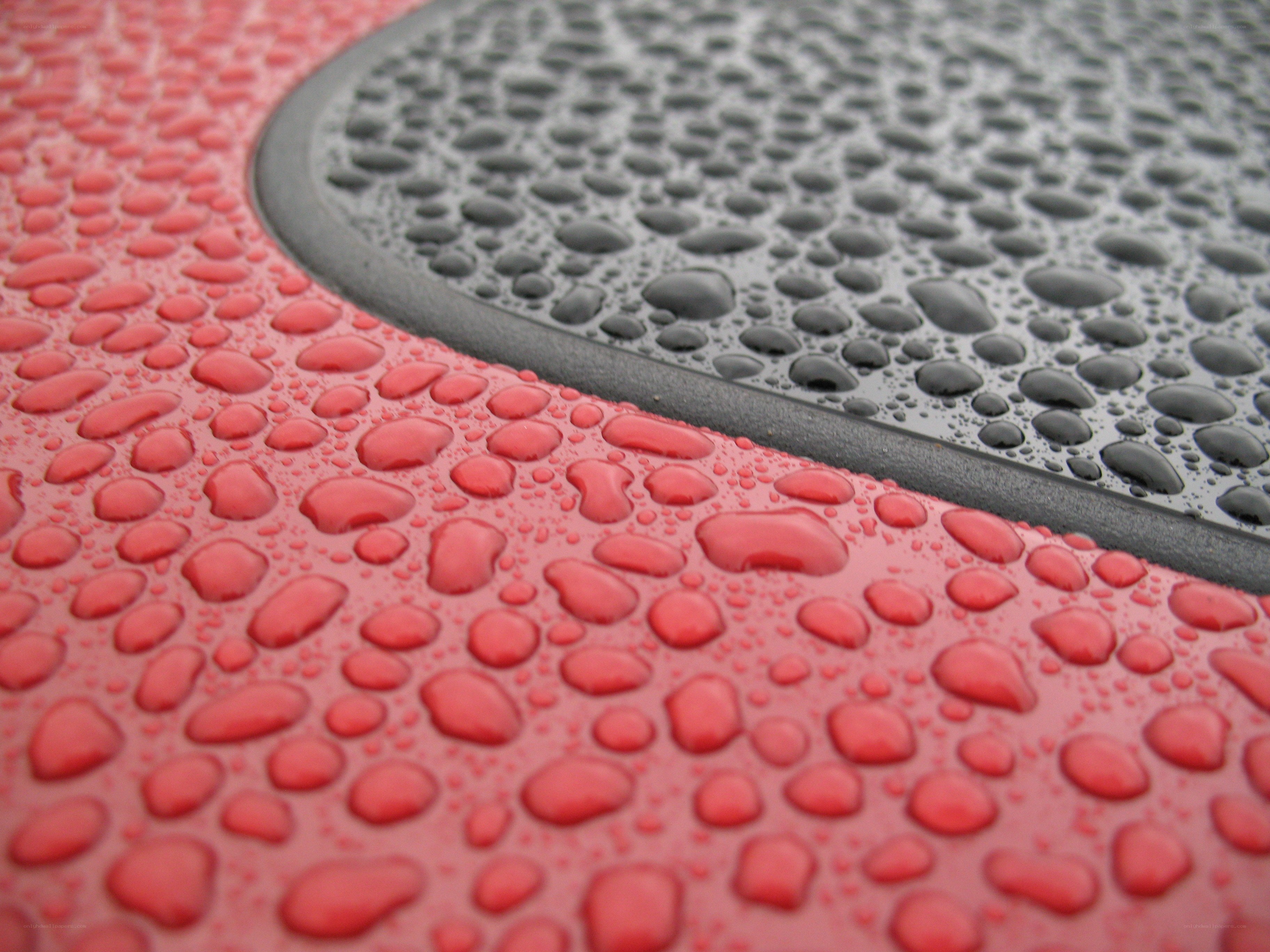 Water droplets on red and black surface