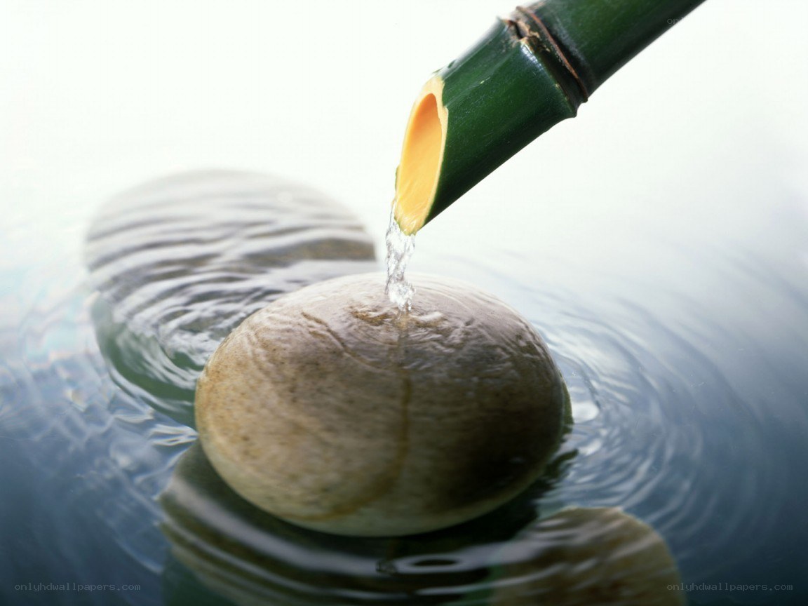 Water flowing from bamboo into stone