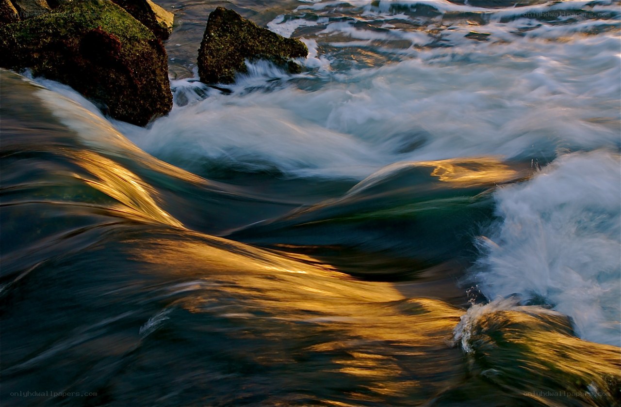 Water flowing over rocks at sunset
