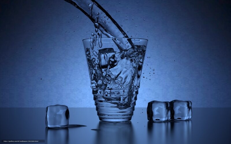 Water pouring into glass with ice