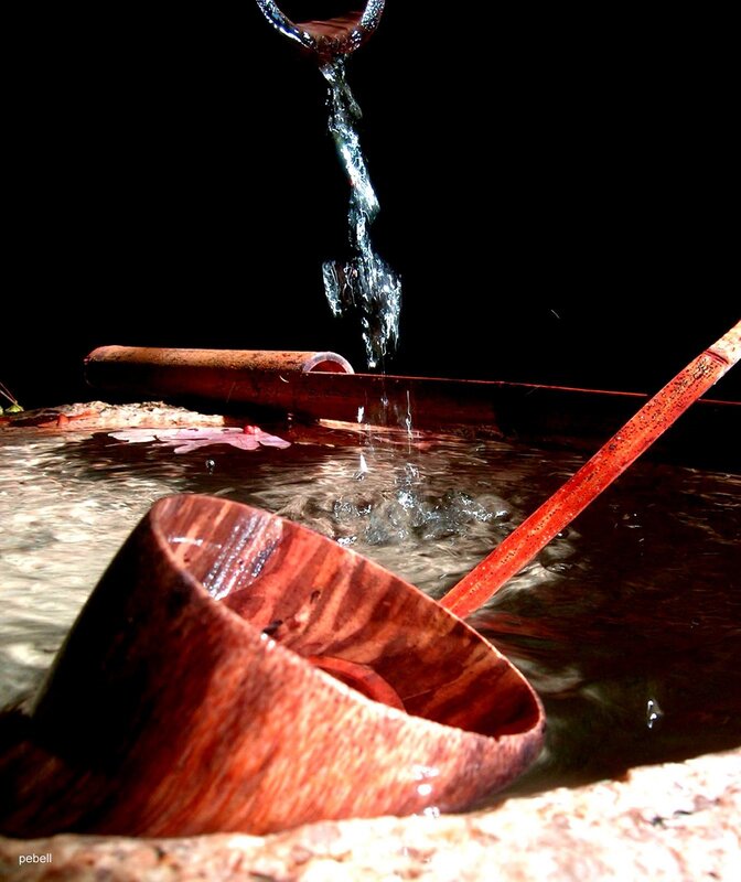 Water pouring into wooden bowl
