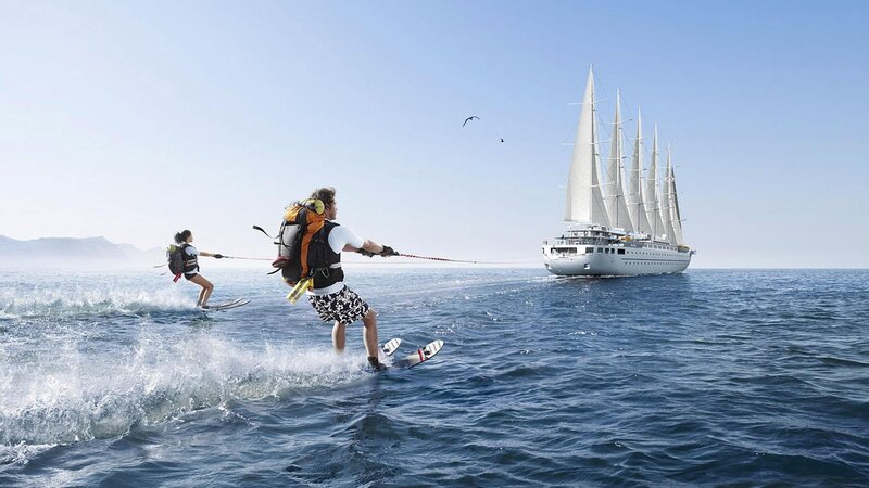 Water skiing near a sailing ship