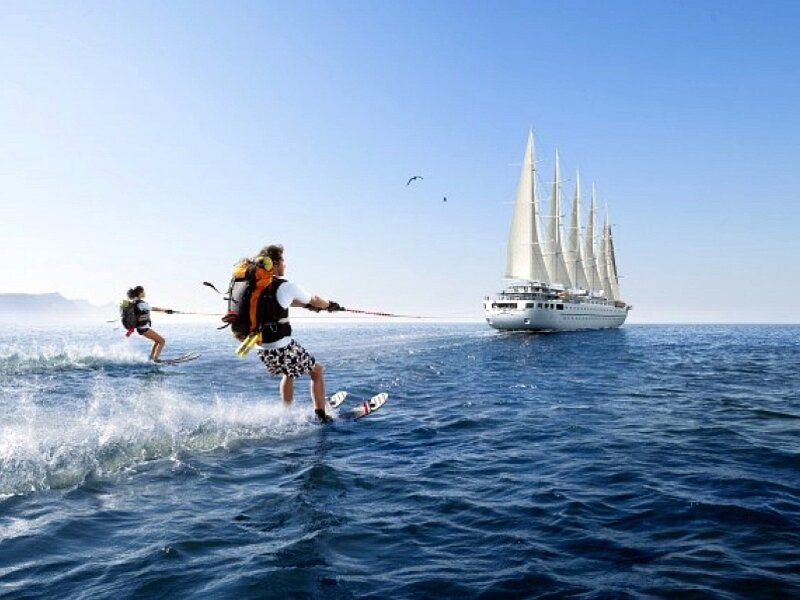 Water skiing near a tall ship
