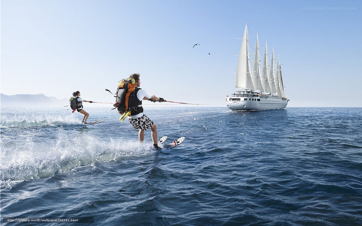 Water skiing near sailboat