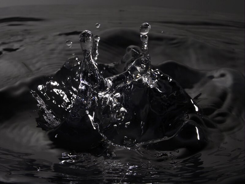 Water splash in dark liquid