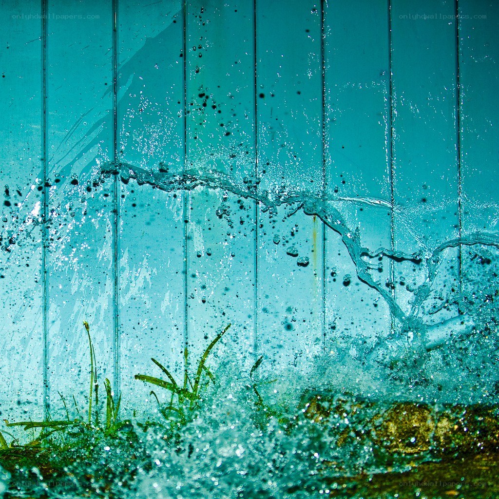 Water splashing against a blue wall