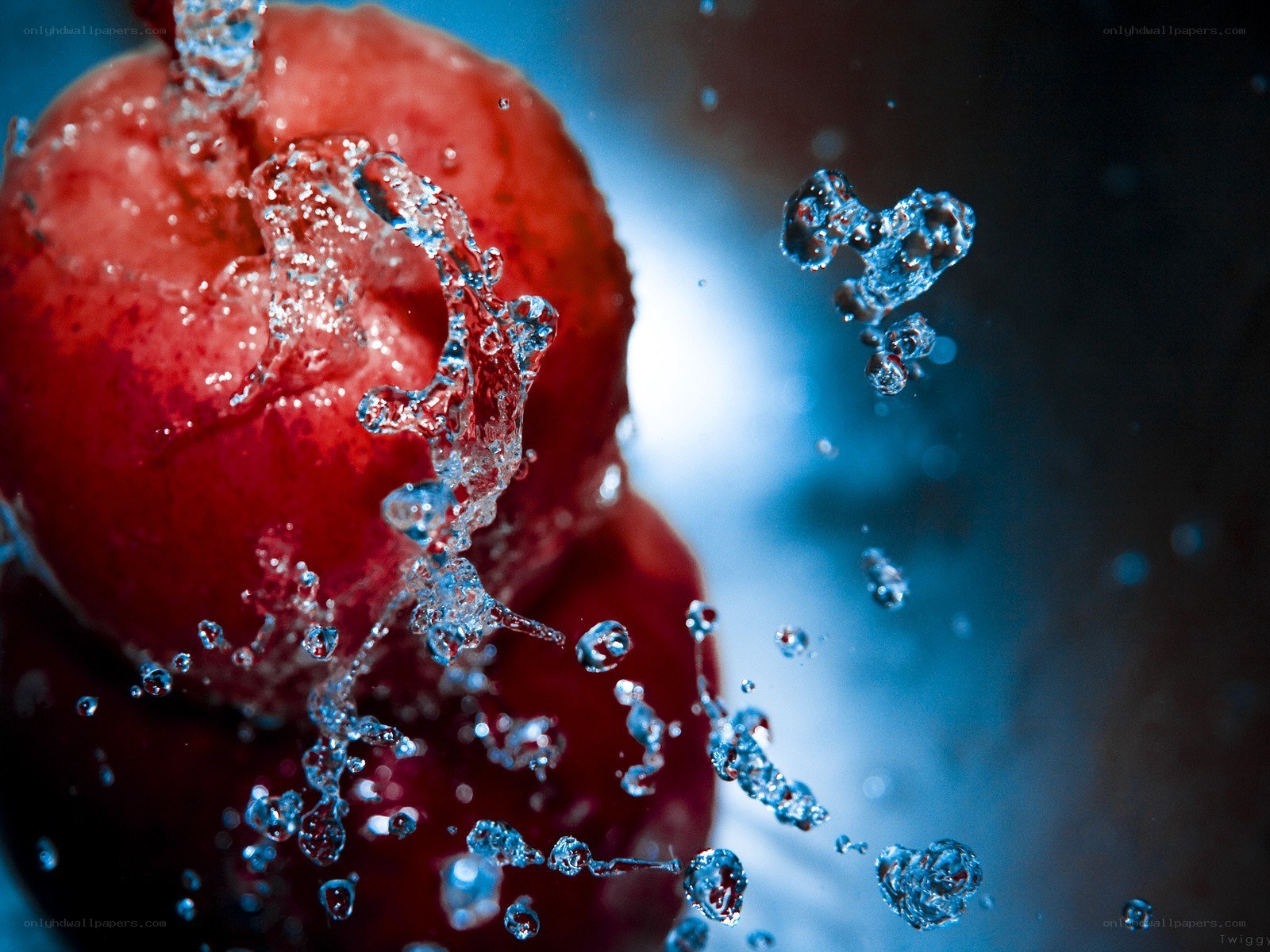 Water splashing on red fruit