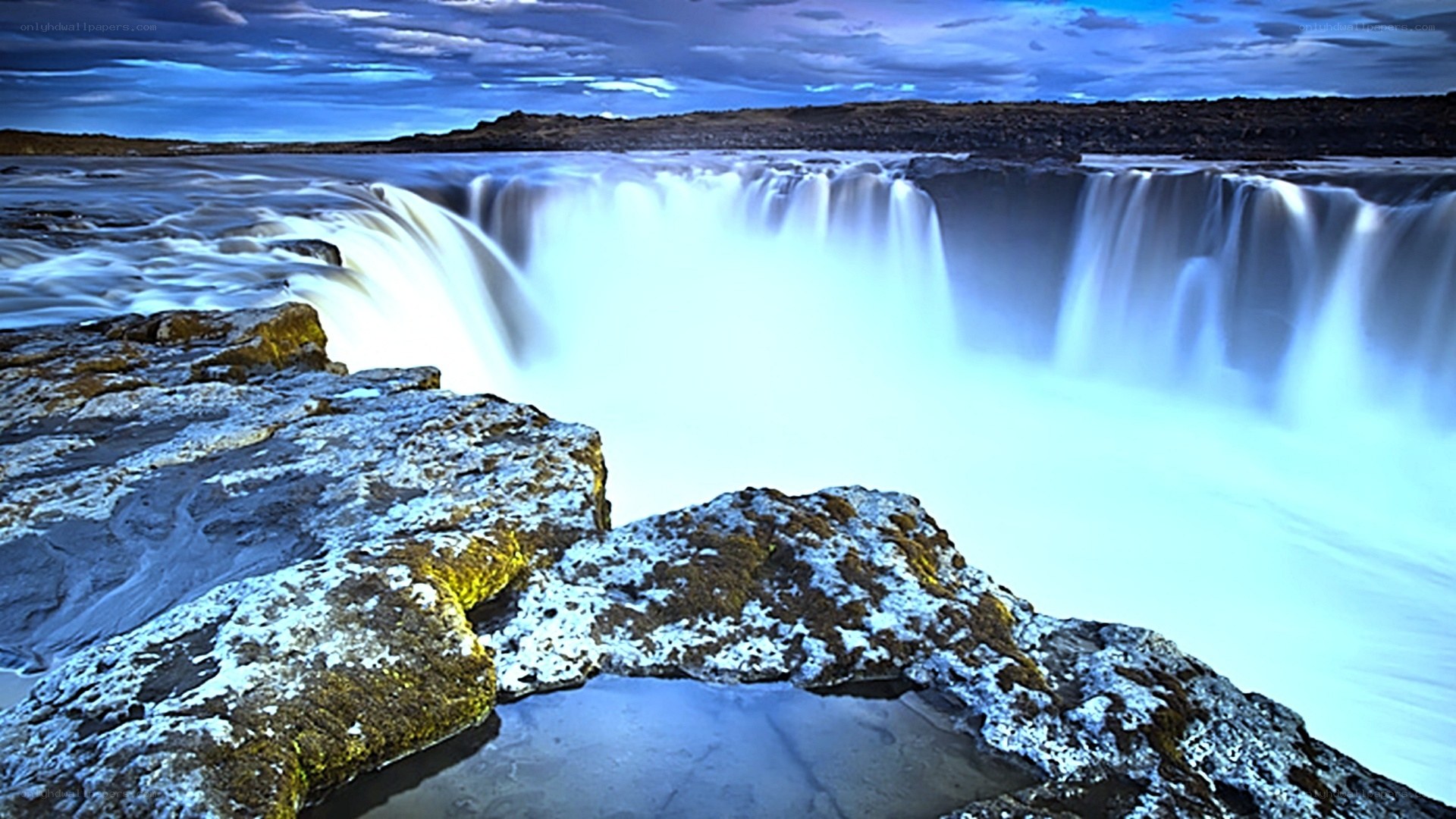 Waterfall at dusk with rocky foreground