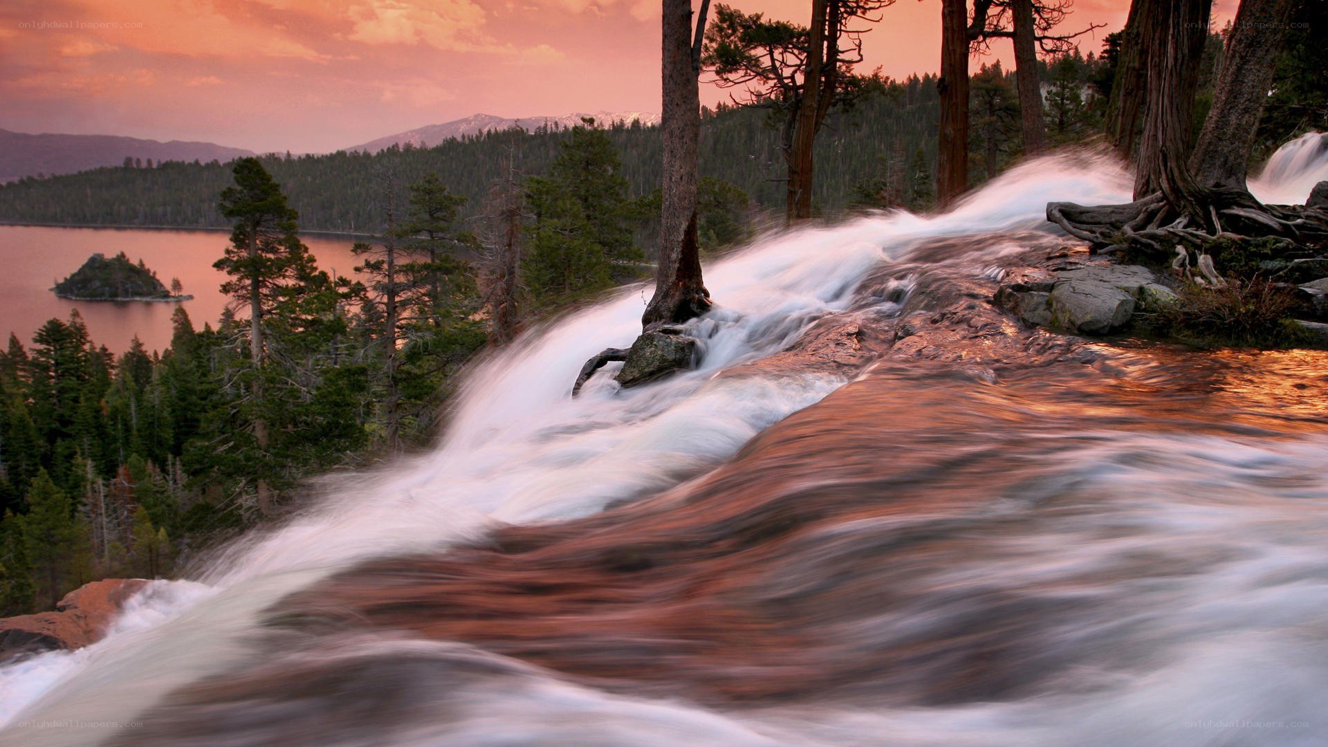 Waterfall at sunset by a lake