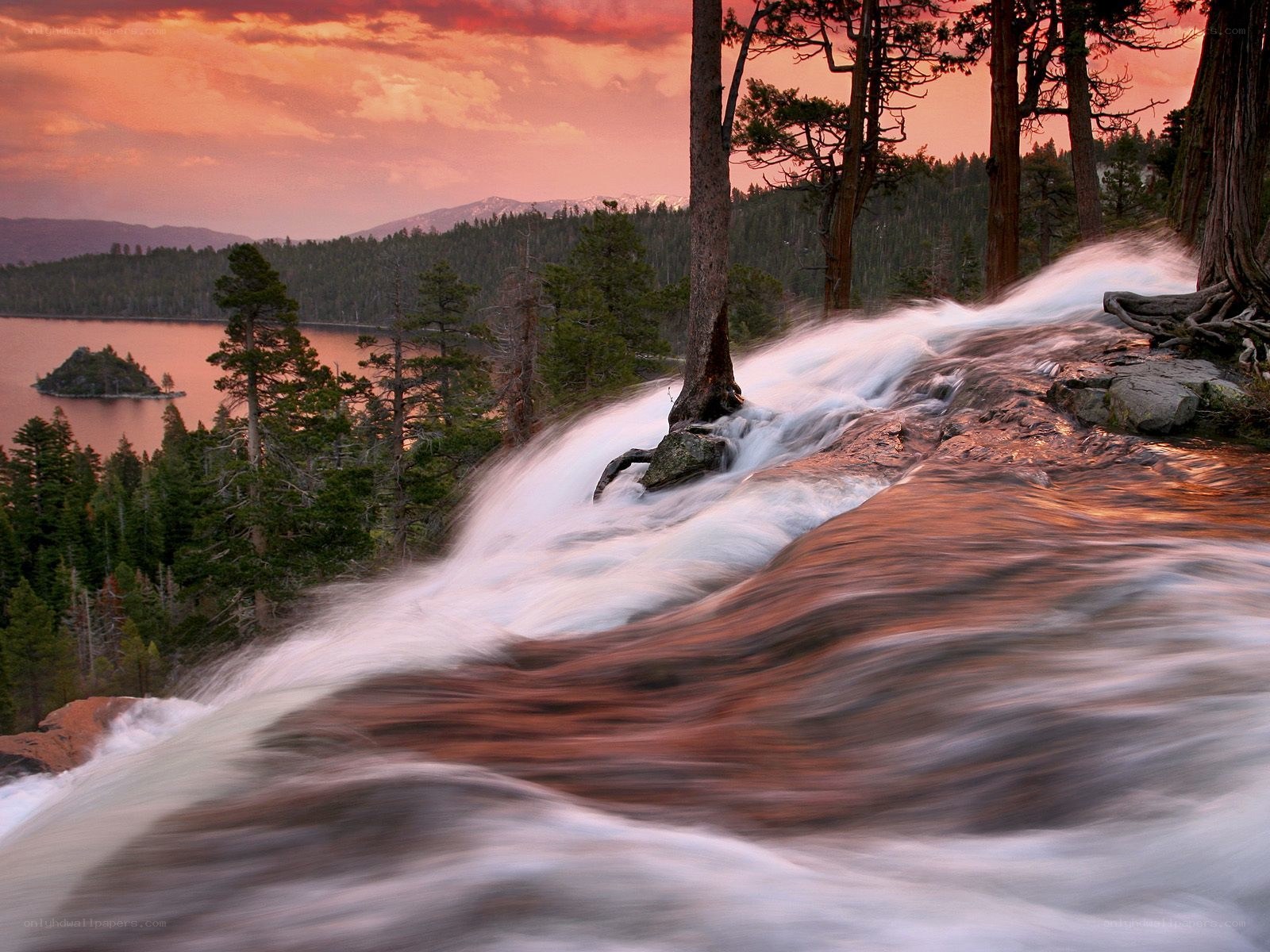 Waterfall at sunset by a lake