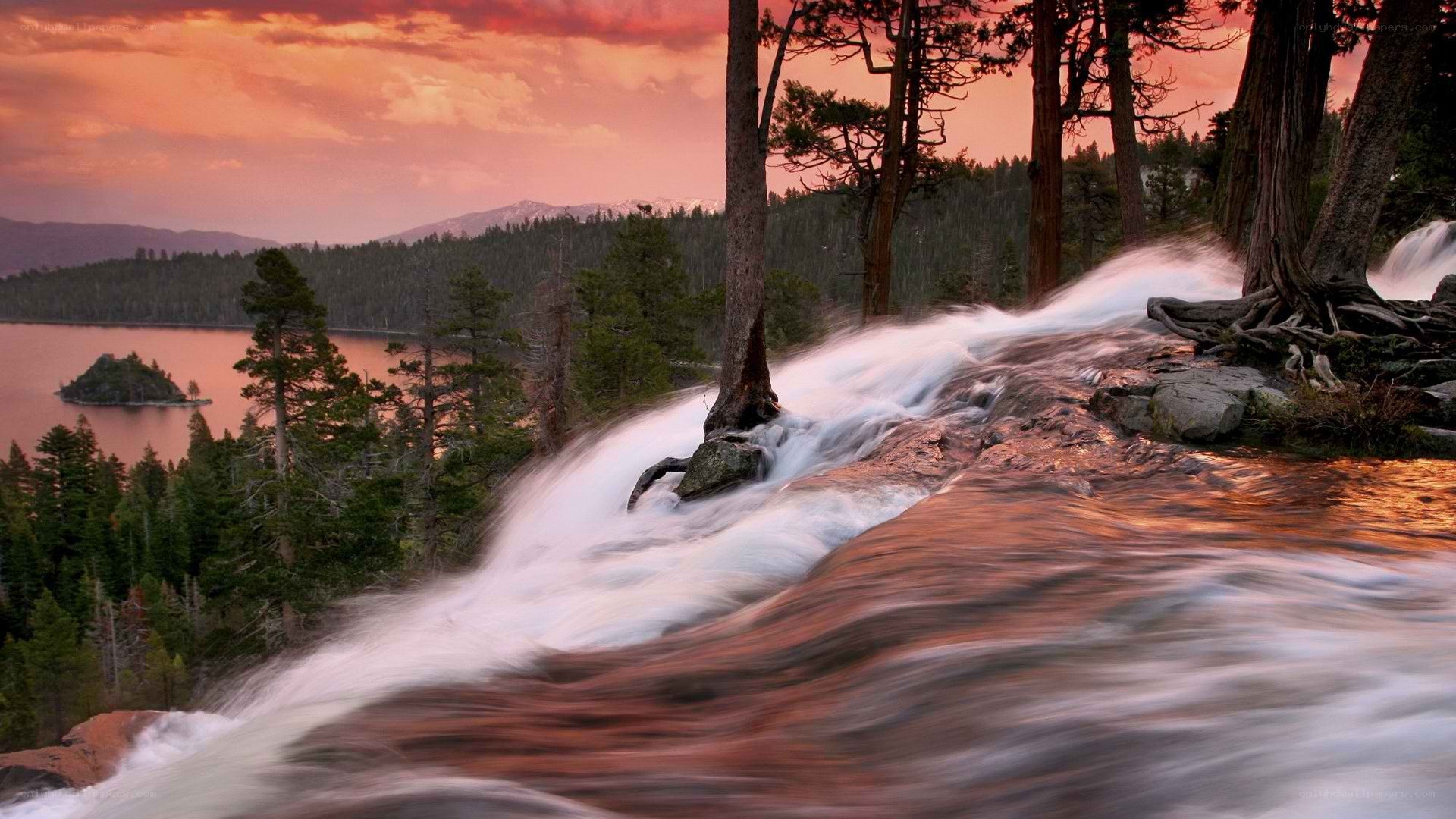 Waterfall at sunset by a lake