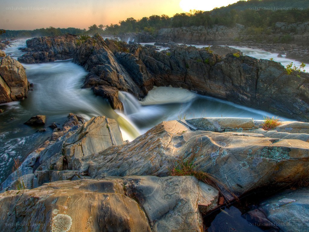Waterfall at sunset over rocks
