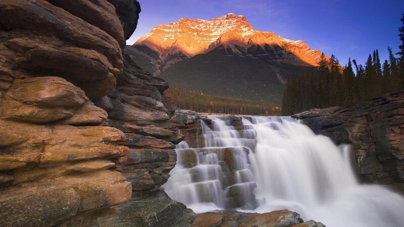 Waterfall at sunset with mountain