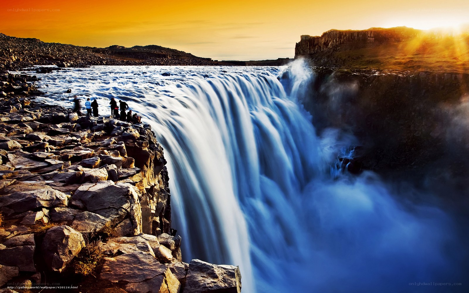 Waterfall at sunset with tourists