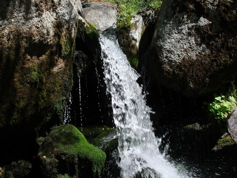 Waterfall between mossy rocks