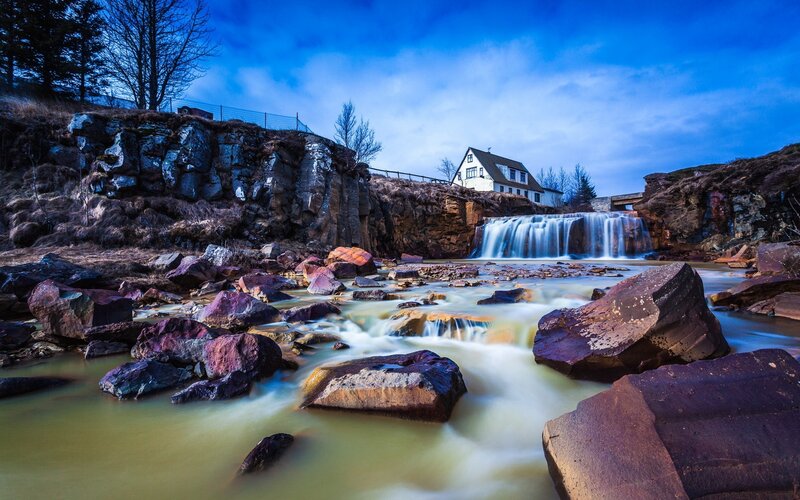 Waterfall by a house in Iceland