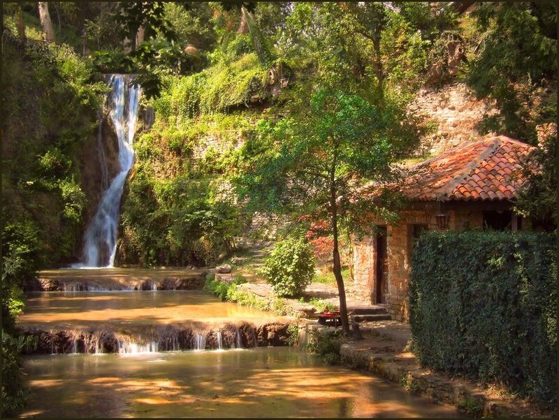 Waterfall by stone cottage