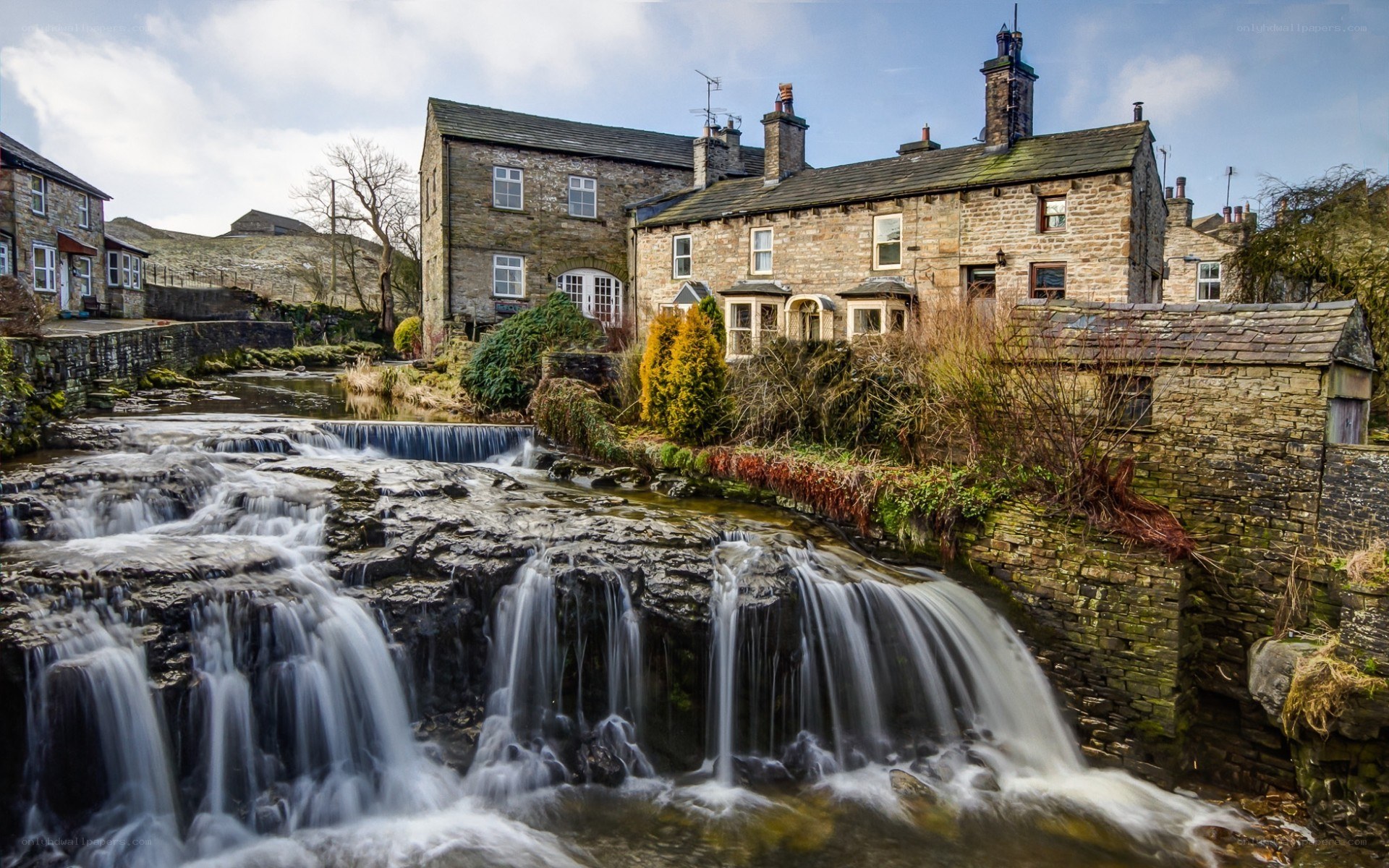 Waterfall by stone houses
