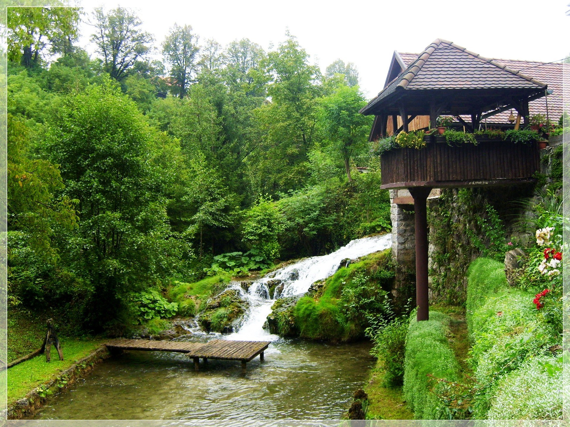 Waterfall by wooden house