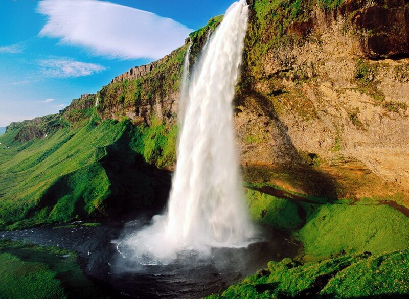 Waterfall cascading down a green cliff