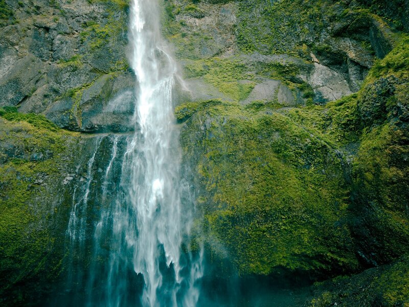 Waterfall cascading down mossy cliff