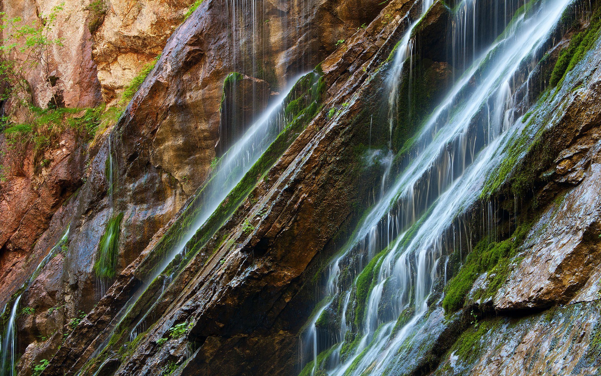 Waterfall cascading down mossy cliff