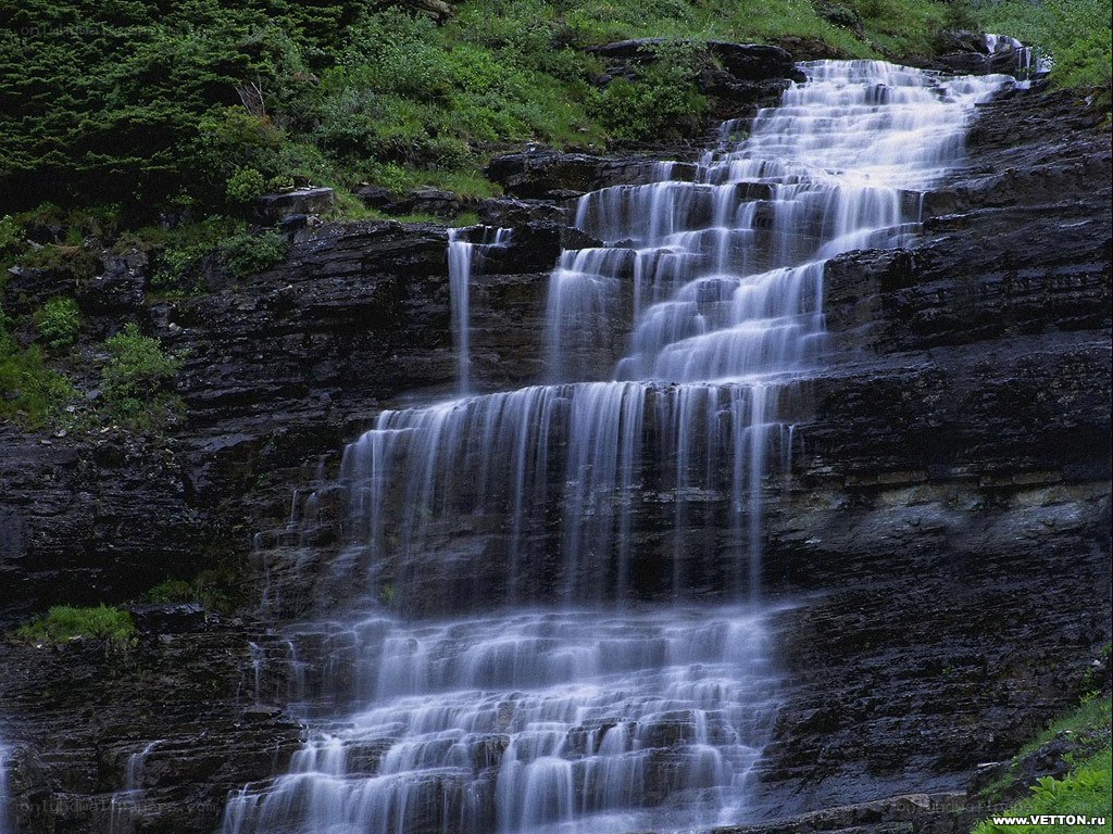 Waterfall cascading down rocky cliff