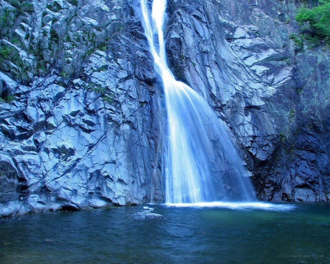 Waterfall cascading down rocky cliff