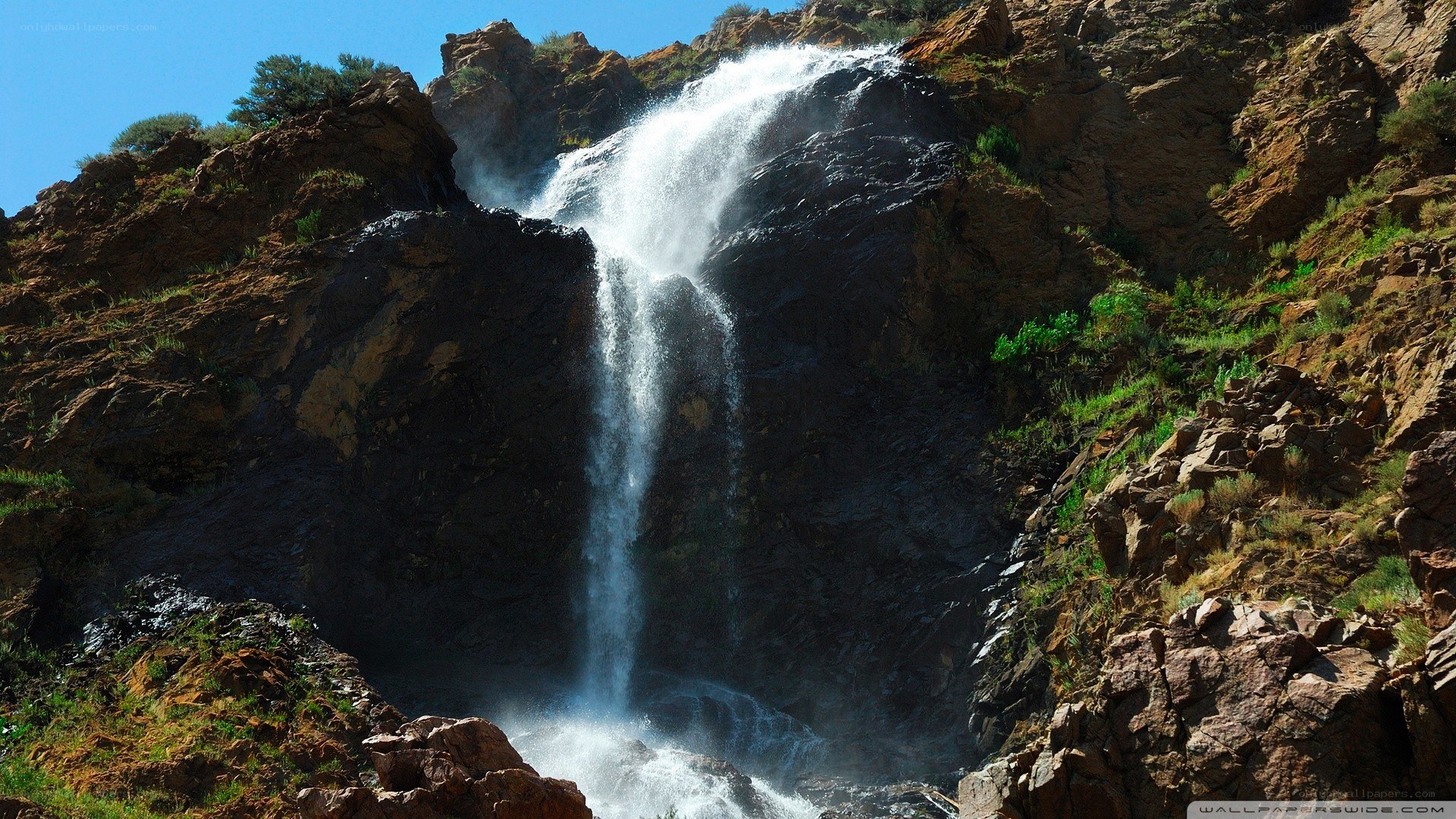 Waterfall cascading down rocky cliff
