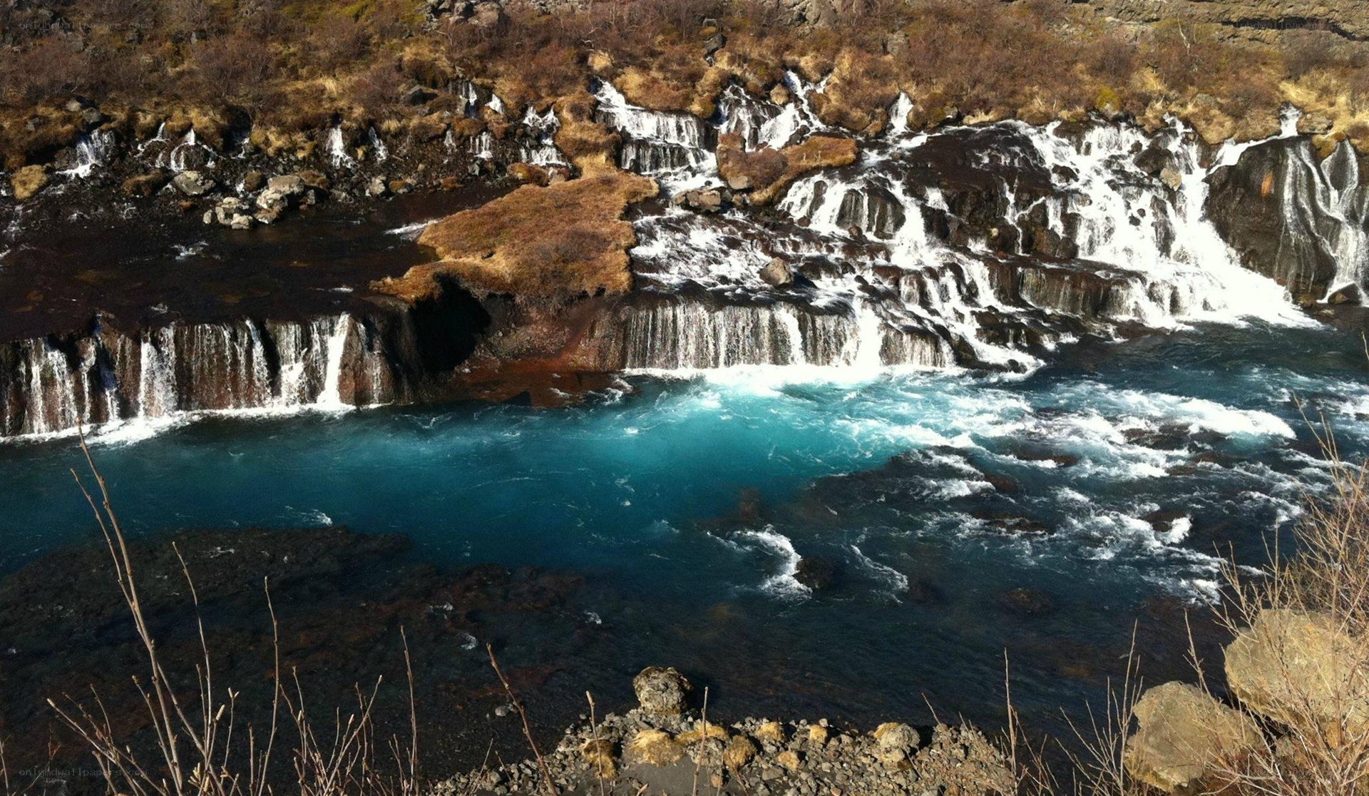 Waterfall cascading into turquoise pool