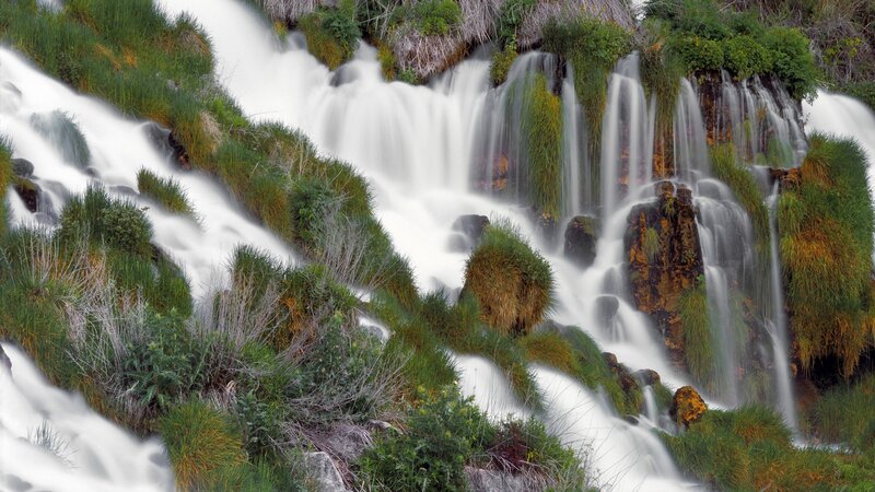 Waterfall cascading over green rocks