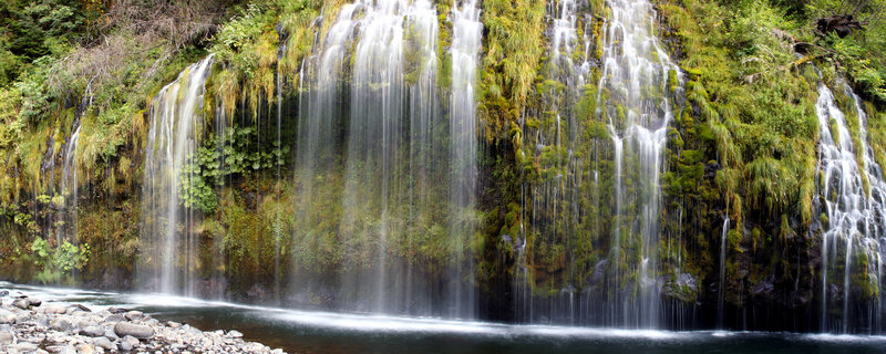 Waterfall cascading over mossy cliff