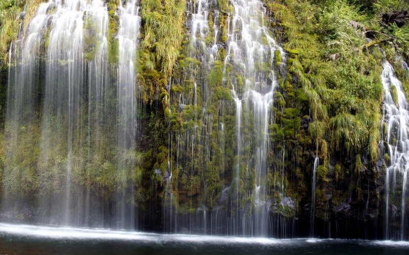 Waterfall cascading over mossy cliff
