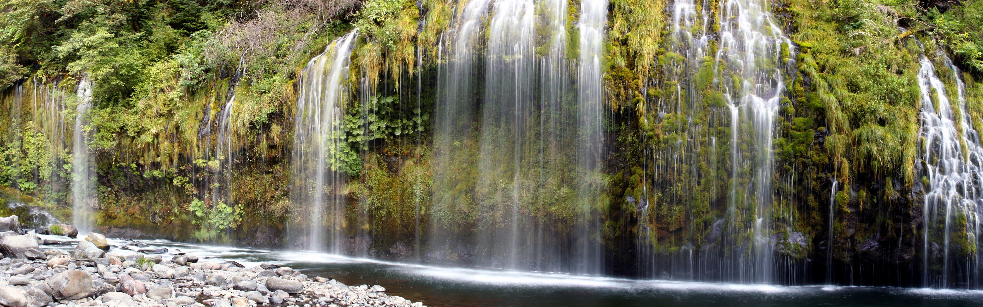 Waterfall cascading over mossy cliff