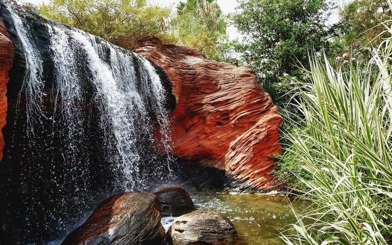 Waterfall cascading over red rock