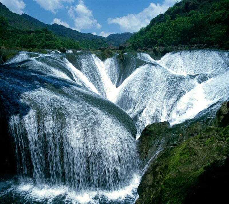 Waterfall Cascading over Rocks — Blue