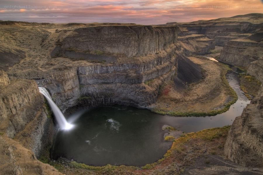 Waterfall in a canyon at sunset
