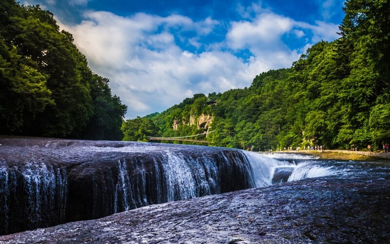 Waterfall in Forest — Green, Serene, Afternoon, Photograph, Trees, Bridge, People
