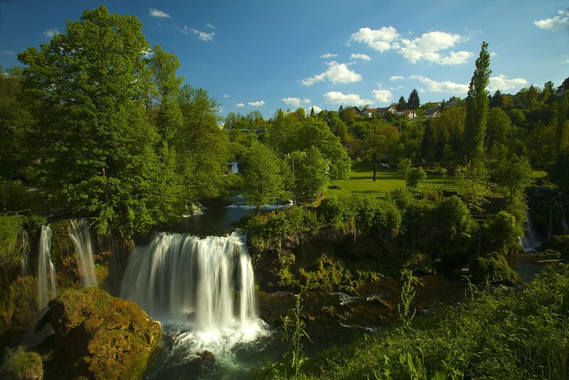 Waterfall in Forest — Green, Serene, Afternoon, Photograph, Trees, River, Grass, Houses