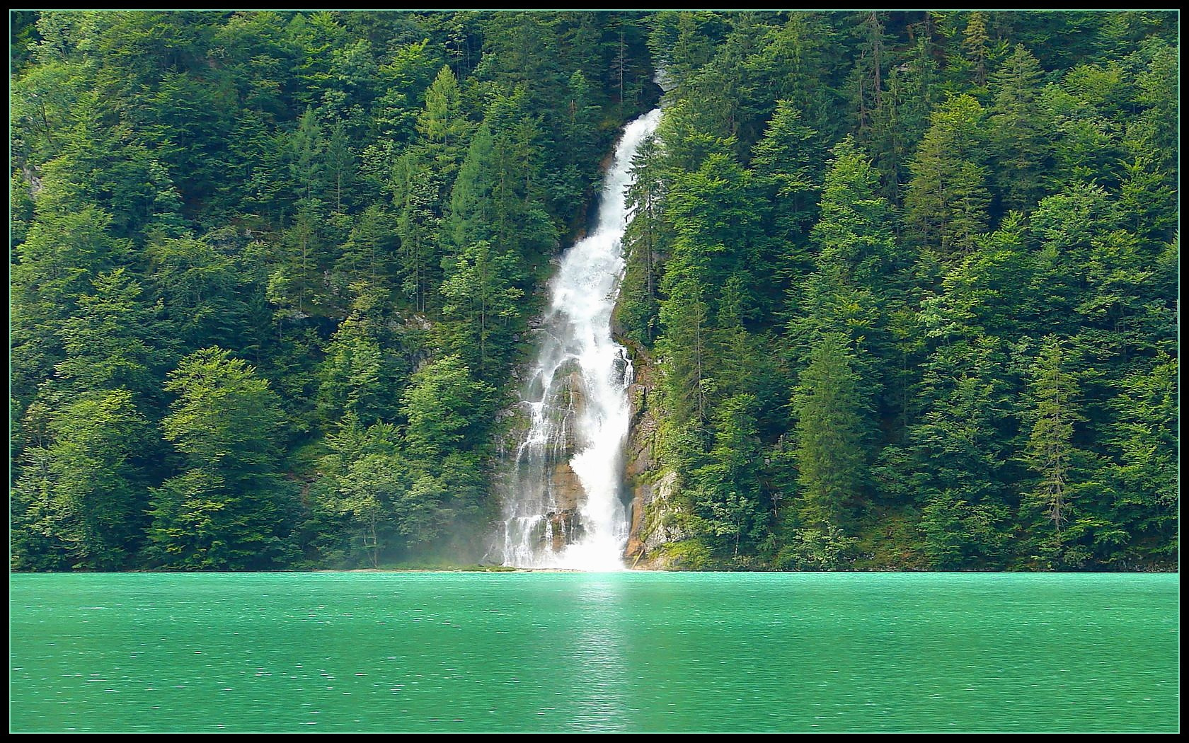 Waterfall into turquoise lake